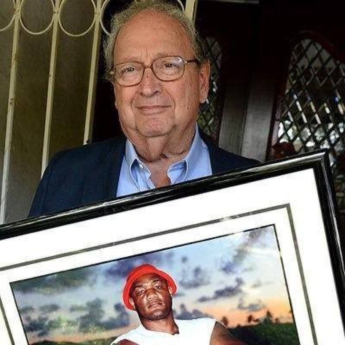 Boxing publicist Bill Caplan holds a photo of George Foreman.