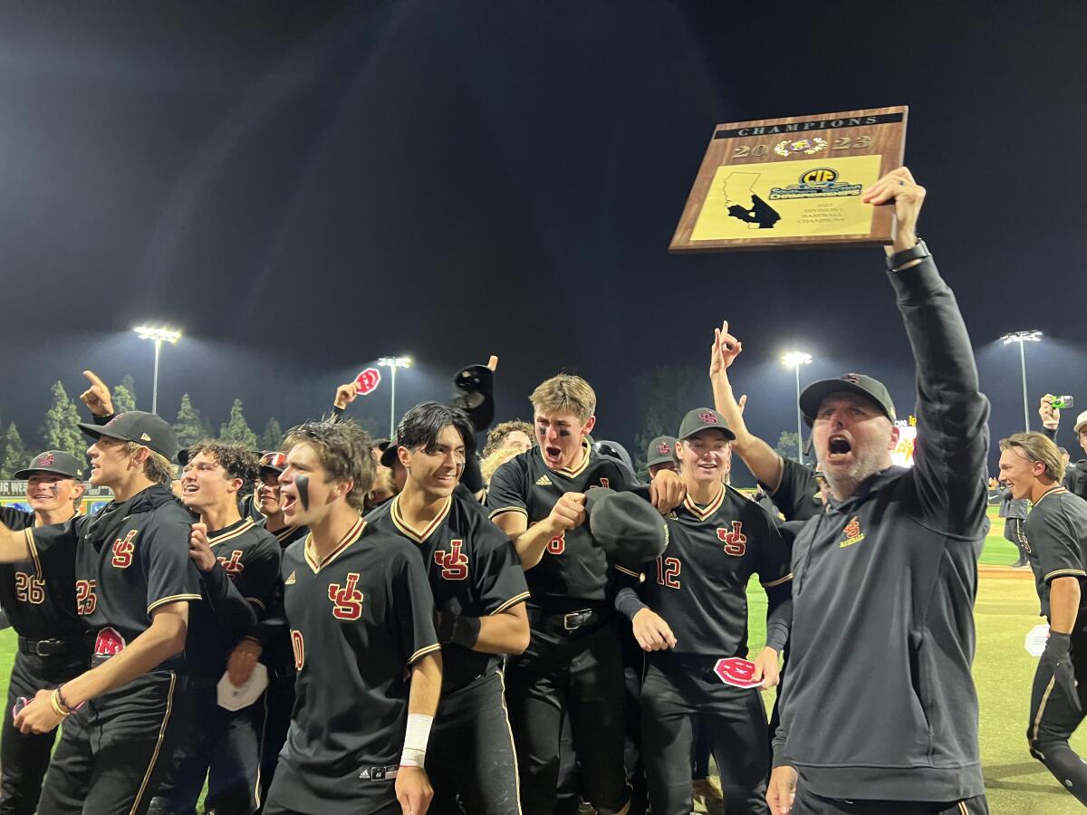 JSerra coach Brett Kay and his players celebrate a second straight Division 1 baseball title with a 1-0, eight-inning win. 