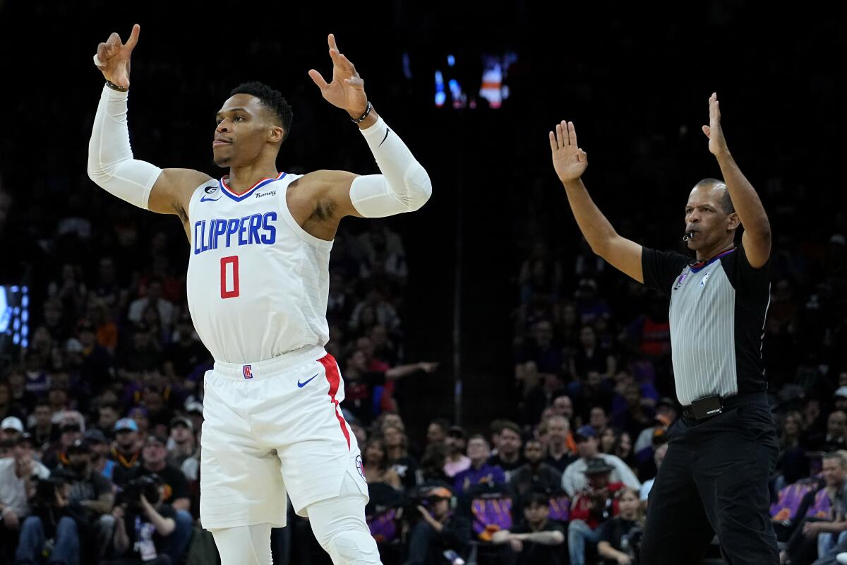 Clippers guard Russell Westbrook, as well as the referee behind him, signals for a three-pointer after making the shot.