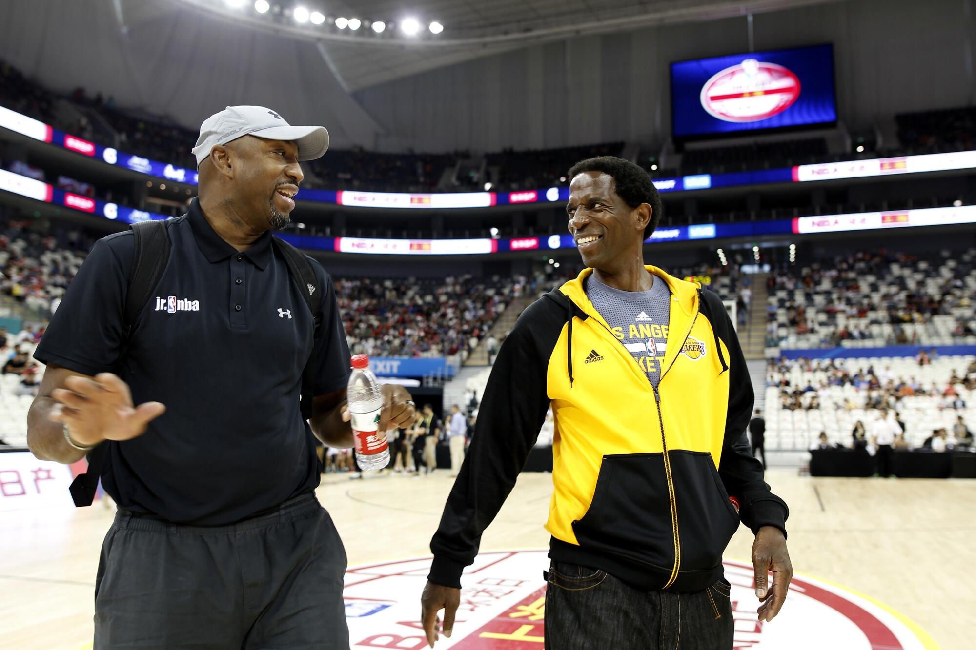 Former NBA stars Vin Baker, left, and A.C. Green walk off the court during a Shanghai fan day in 2016.