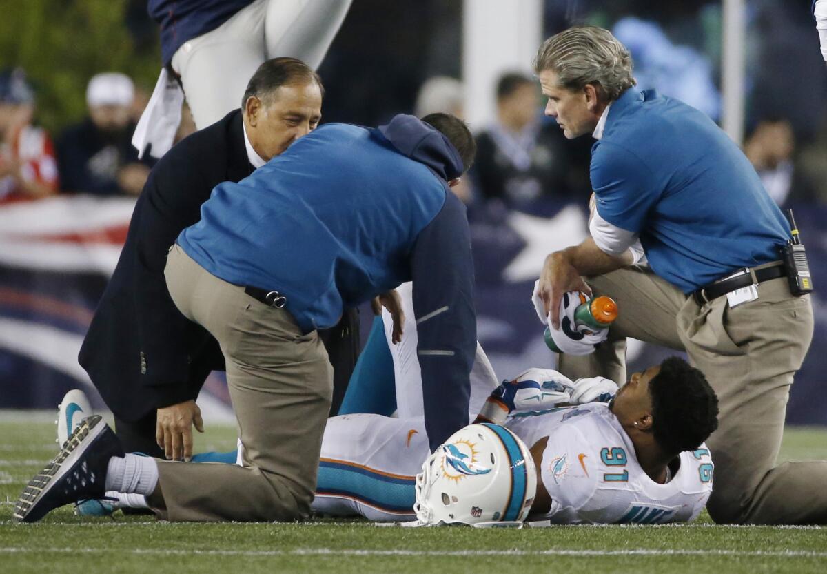 Miami Dolphins defensive end Cameron Wake is tended to after being injured during the third quarter of a 36-7 loss to the New England Patriots on Thursday night.