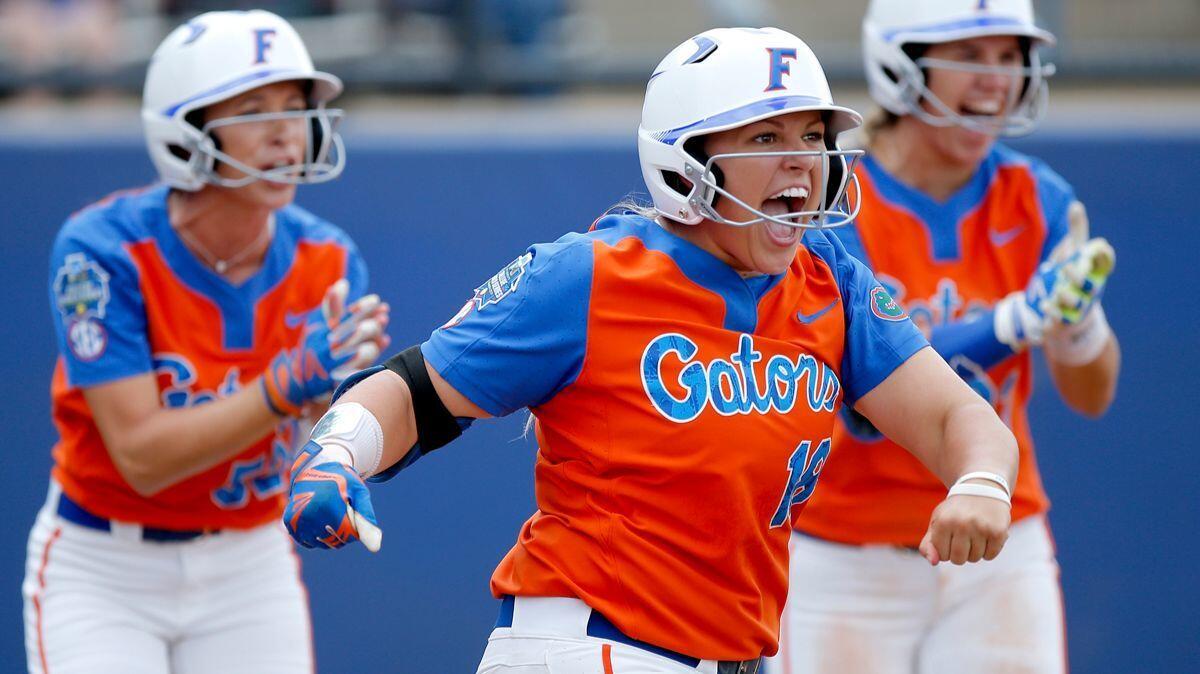 Florida's Amanda Lorenz, foreground, celebrates a score with Justine McLean, left, and Nicole DeWitt during Sunday's game against Washington at the Women's College World Series. All three are from Southern California.
