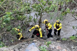 Orange County Fire Authority swift water rescue team members set up in a Laguna Hills creek.