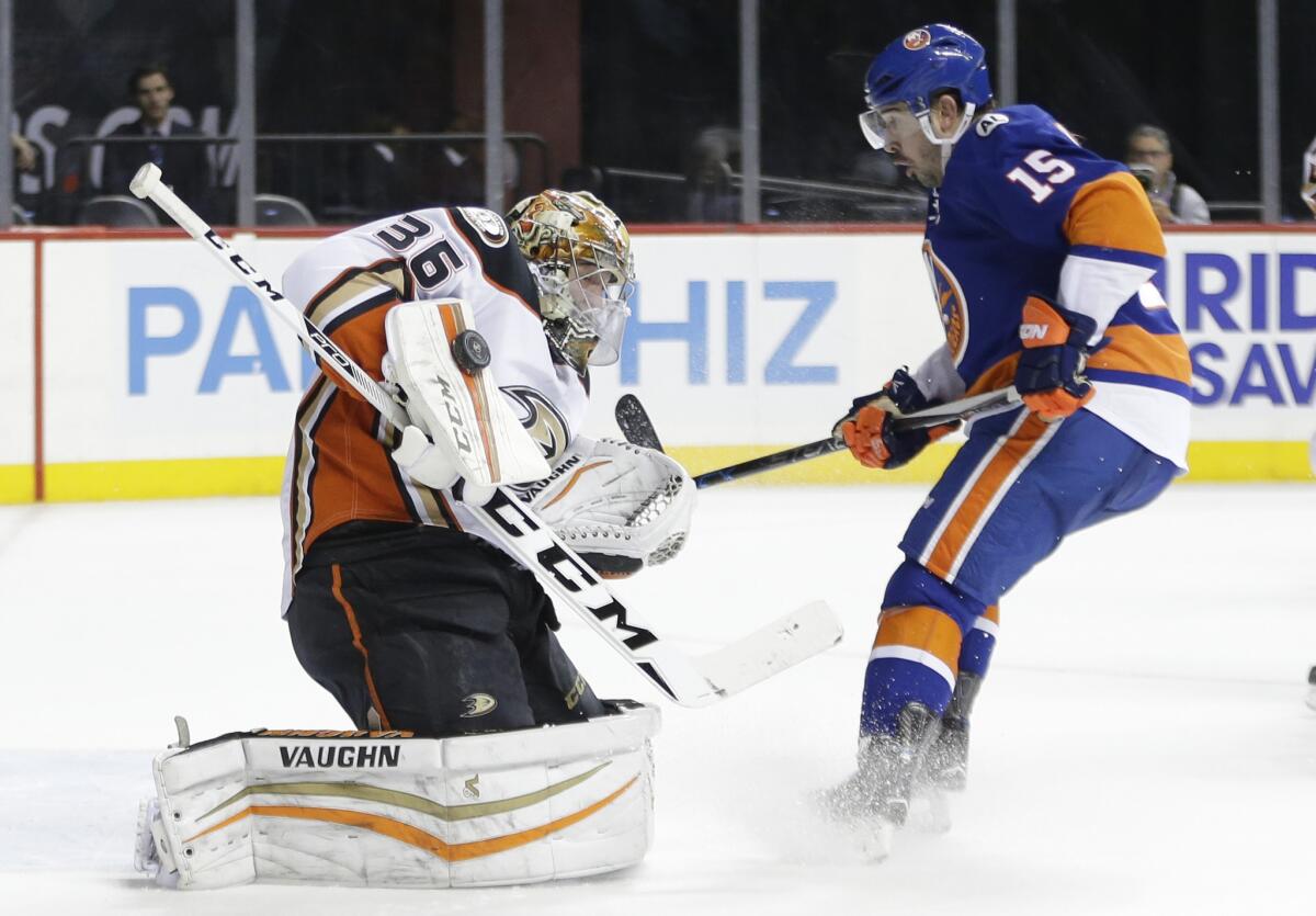 Ducks goalie John Gibson (36) stops a shot on the goal as the Islanders' Cal Clutterbuck (15) closes in during the second period Monday.