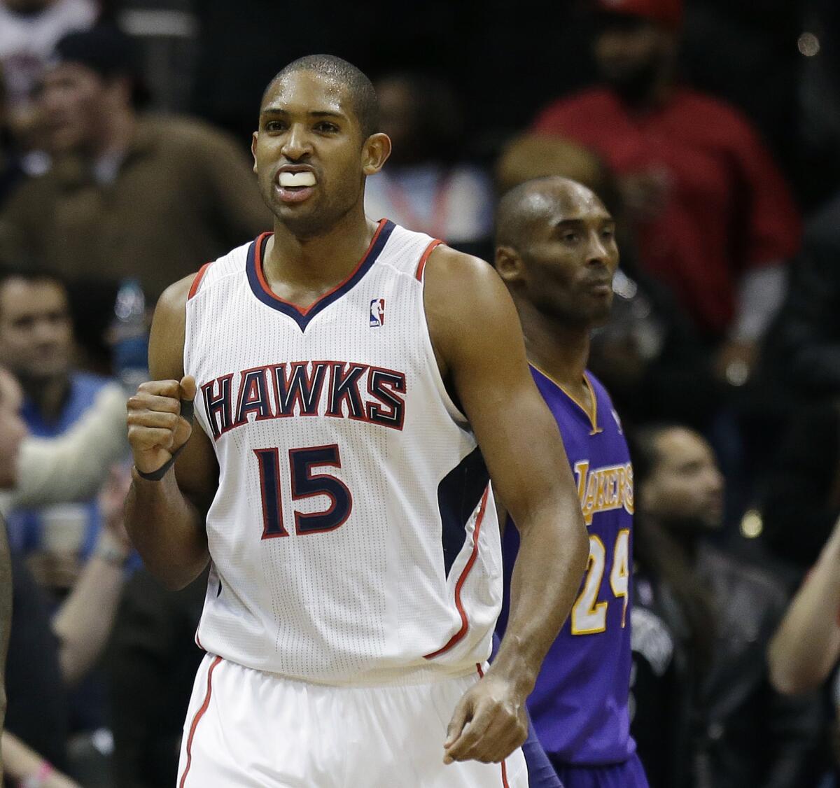 Hawks forward Al Horford pumps his fist in front of Lakers star Kobe Bryant after scoring a basket during a Dec. 16, 2013, game in Atlanta.