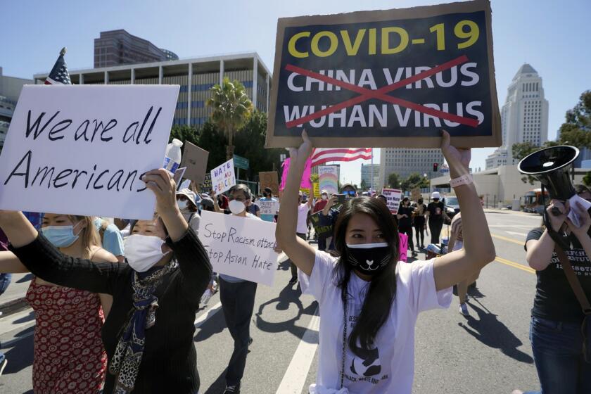 Protestors march at a rally against Asian hate crimes past the Los Angeles Federal Building in downtown Los Angeles , Saturday, March 27, 2021. The gathered crowd demanded justice for the victims of the Atlanta spa shooting and for an end to racism, xenophobia and misogyny. The "LA vs. Hate" initiative encourages people to call 211 if they are victims or witness an incident of hate. (AP Photo/Damian Dovarganes)