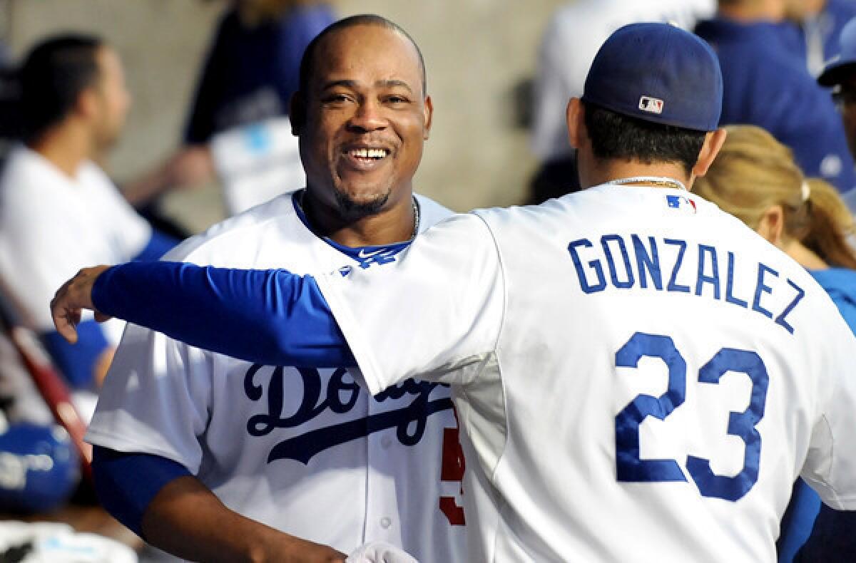 Dodgers infielder Juan Uribe gets a hug from first baseman Adrian Gonzalez as they prepare to play the San Francisco Giants last summer at Dodger Stadium.