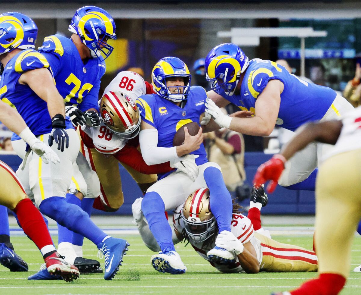 Rams quarterback Matthew Stafford (9) is sacked by 49ers  Arden Key (98) and Fred Warner (54).