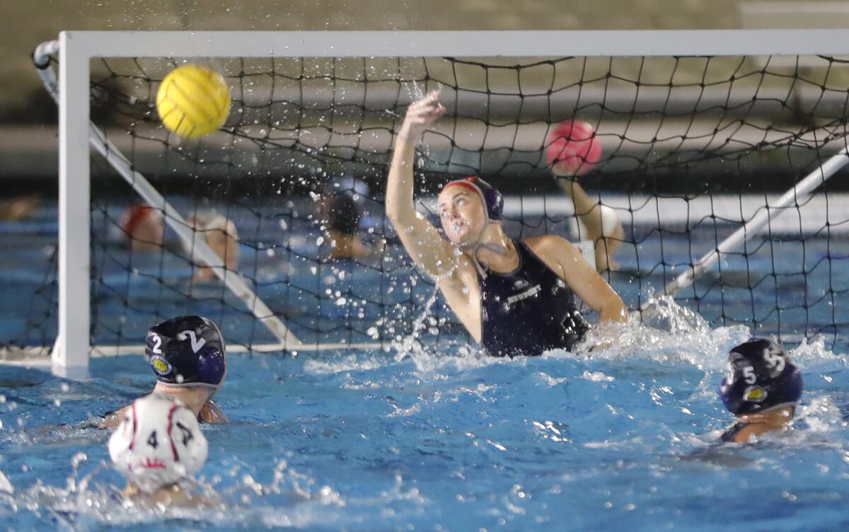 Newport Harbor goalie Anna Reed tips the ball away during the annual Battle of the Bay girls' water polo match on Thursday.