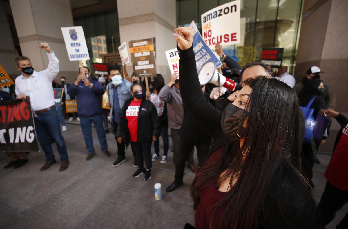 Workers hold signs during a rally