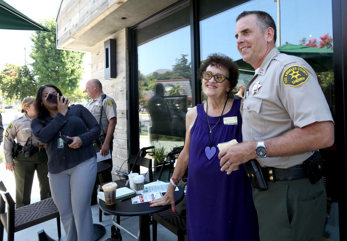 La Cañada Flintridge Chamber of Commerce Ambassador Harriet Hammons takes a photo with Crescenta Valley Sheriff Station captain Todd Deeds, during "Coffee with the Captain" event at the Starbucks in La Cañada Flintridge on Thursday, Aug. 29.