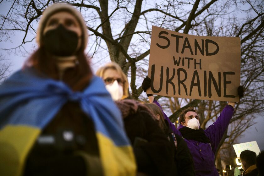 A man holds a poster in support of Ukraine as he attends a demonstration near the Russian embassy to protest against the escalation of the tension between Russia and Ukraine in Berlin, Germany, Tuesday, Feb. 22, 2022. Lawmakers gave Russian President Vladimir Putin permission to use military force outside the country on Tuesday. The move that could presage a broader attack on Ukraine after the U.S. said an invasion was already underway there. (AP Photo/Markus Schreiber)