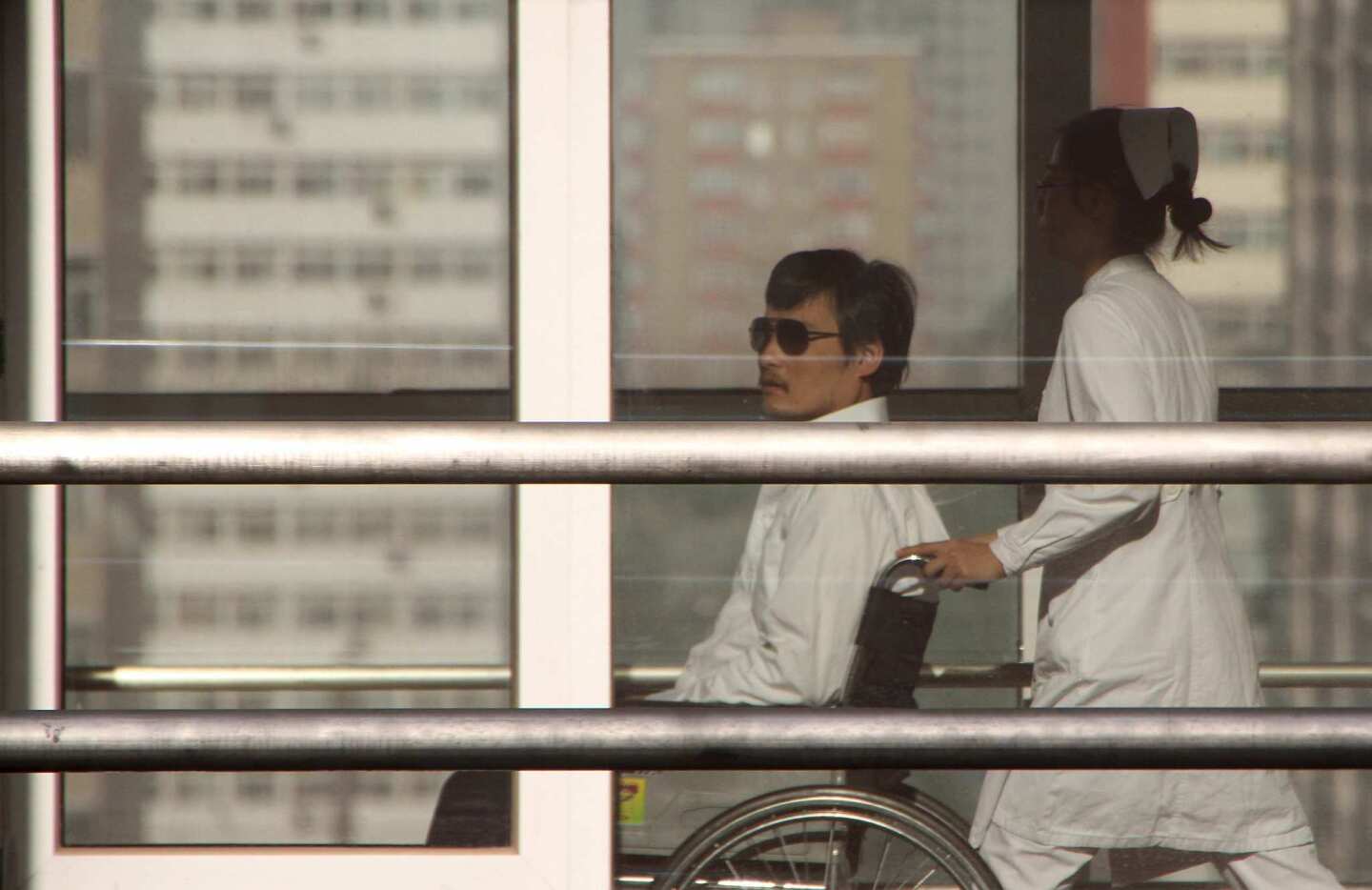 Chinese activist Chen Guangcheng is transported by a nurse at the Chaoyang Hospital in Beijing.