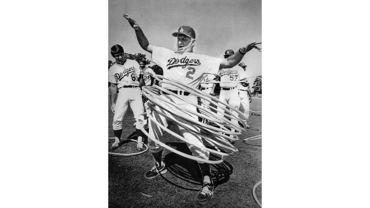 Tommy Lasorda tries to swing nine hula hoops