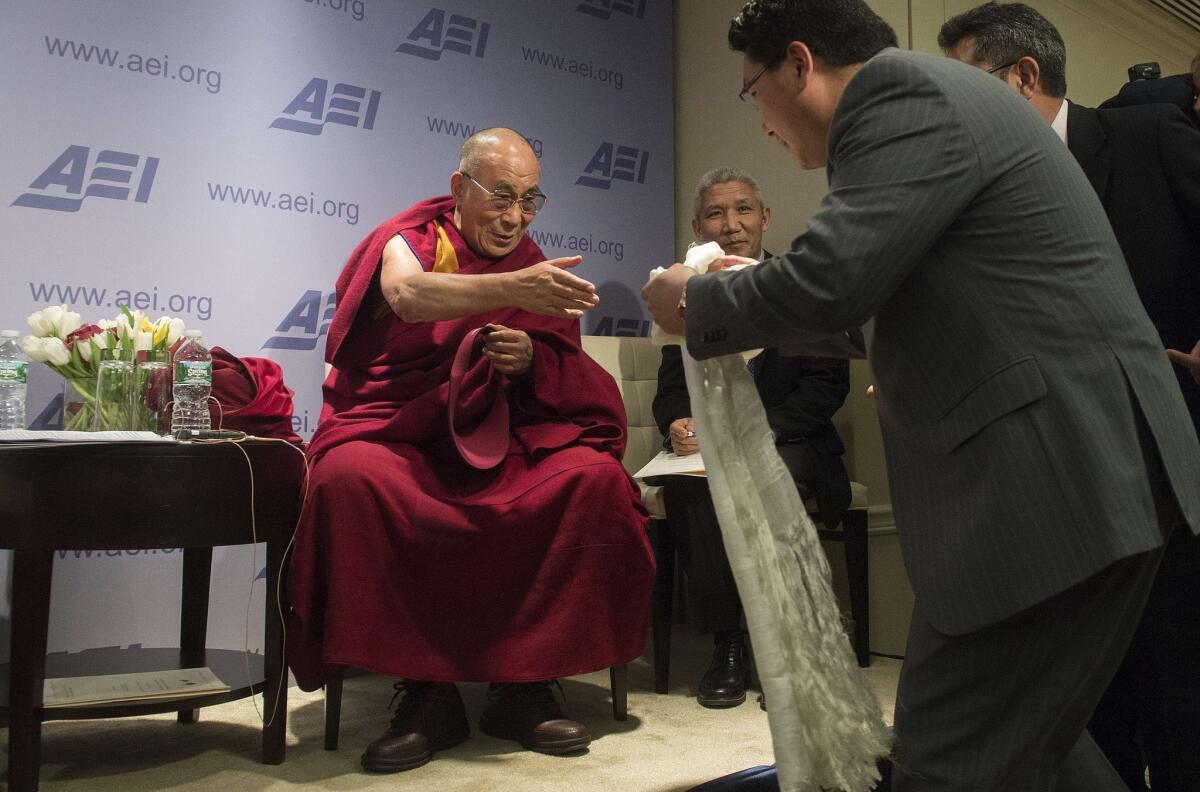 A man has his white scarf blessed during a greeting with the Dalai Lama at an American Enterprise Institute panel discussion in Washington. The Dalai Lama will visit President Obama at the White House on Friday.
