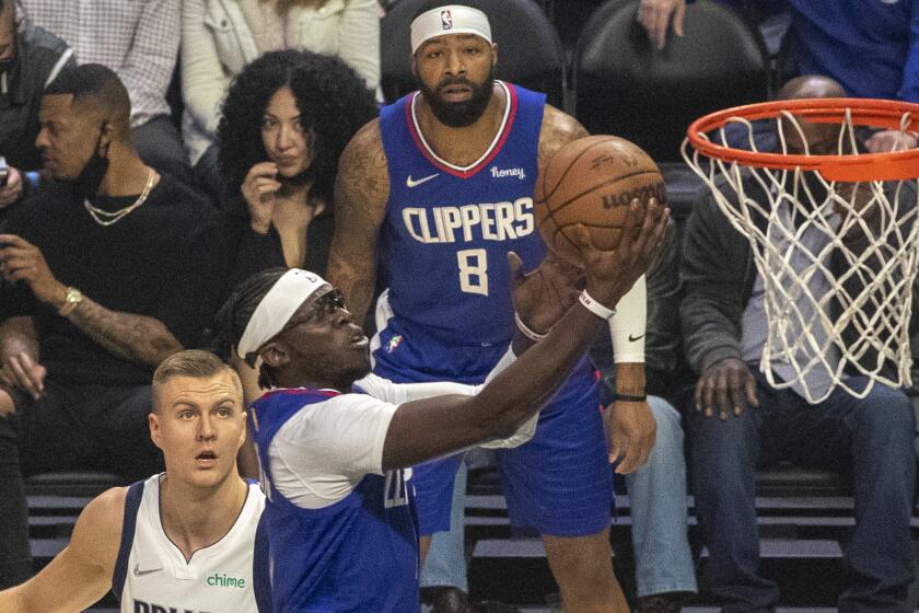 Clippers guard Reggie Jackson takes it to the basket past Dallas Mavericks center Kristaps Porzingis 