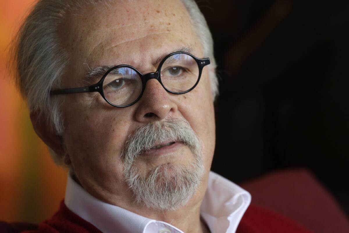 A photo of artist Fernando Botero, who has round-frame black glasses, gray receding hair and a goatee