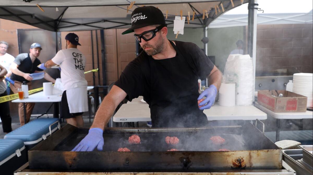 Shawn Nee, creator, prepares burgers during the Burgers Never Say Die pop-up at the Glendale Tap in Glendale.