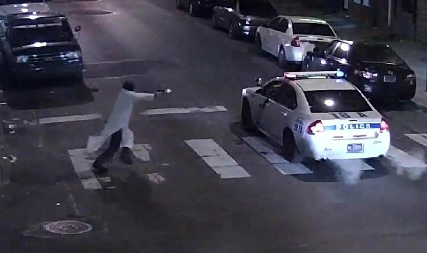 This video still image obtained January 8, 2016 courtesy of the Philadelphia Police Department, shows a shooting suspect and police car on January 7, 2016 in Philadelphia, Pa.