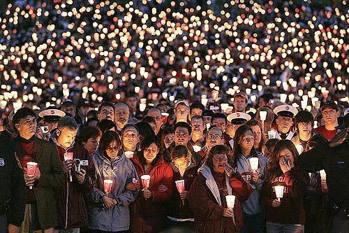 Thousands of Virginia Tech students, staff and family hold a vigil at the university's parade grounds a day after a gunman killed 32 and himself and injured more than two dozen.
