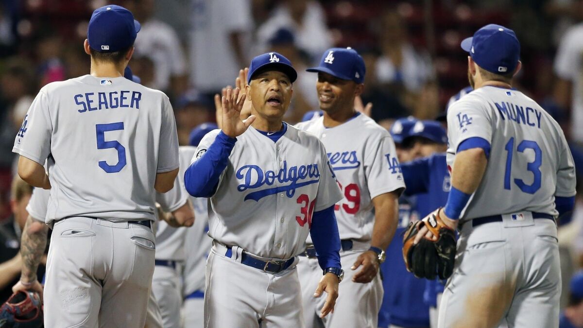 Dodgers manager Dave Roberts (30) celebrates with his team after defeating the Boston Red Sox in the 12th inning in Boston on July 15, 2019.