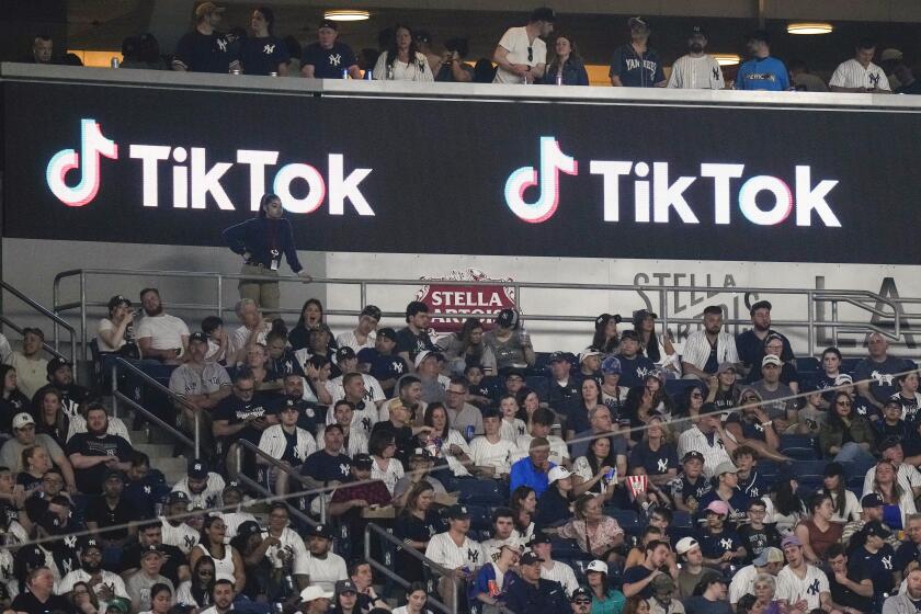 ARCHIVO - Aficionados están sentados bajo un anuncio de TikTok mientras asisten a un partido de béisbol en el Yankee Stadium, el 14 de abril de 2023, en Nueva York. (AP Foto/Frank Franklin II, Archivo)