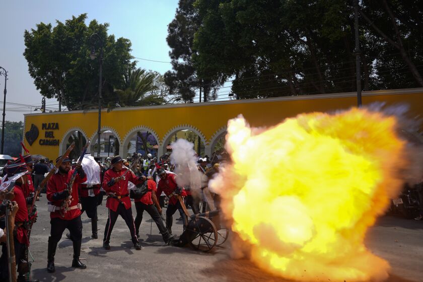A man fires a cannon gun during a recreation of the Battle of Puebla between the Zacapoaxtlas Indians and French army at the Cinco de Mayo celebrations, in the Peñon de los Baños neighborhood of Mexico City, Thursday, May 5, 2022. Cinco de Mayo commemorates the victory of an ill-equipped Mexican army over French troops in Puebla on May 5, 1862. (AP Photo/Eduardo Verdugo)