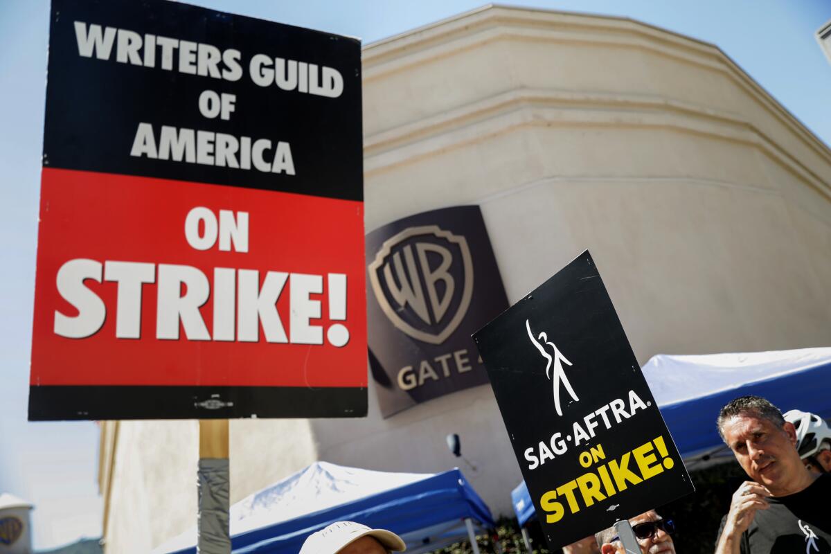 Signs carried by striking writers and actors outside the Warner Bros. studio lot in Burbank.