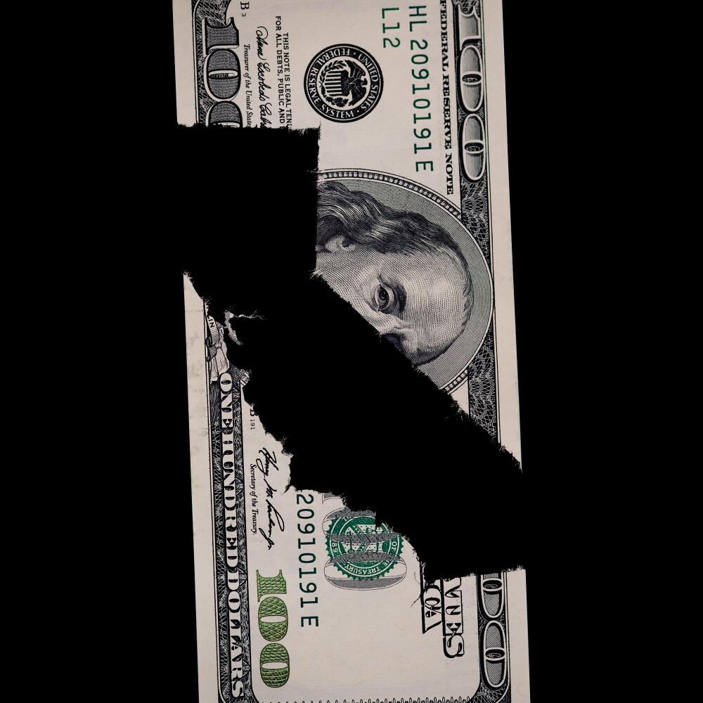 Illustration of the shape of California formed by the negative space between torn pieces of a $100 bill.