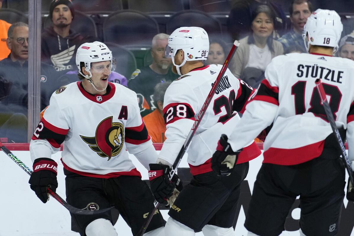 Ottawa Senators' Thomas Chabot, from left, celebrates with Claude Giroux and Tim Stützle after scoring a goal during the first period of an NHL hockey game against the Philadelphia Flyers, Saturday, Nov. 12, 2022, in Philadelphia. (AP Photo/Matt Slocum)