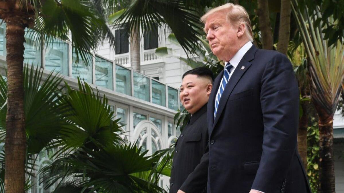 President Trump and North Korean leader Kim Jong Un walk together during a break from talks in Hanoi on Feb. 28.