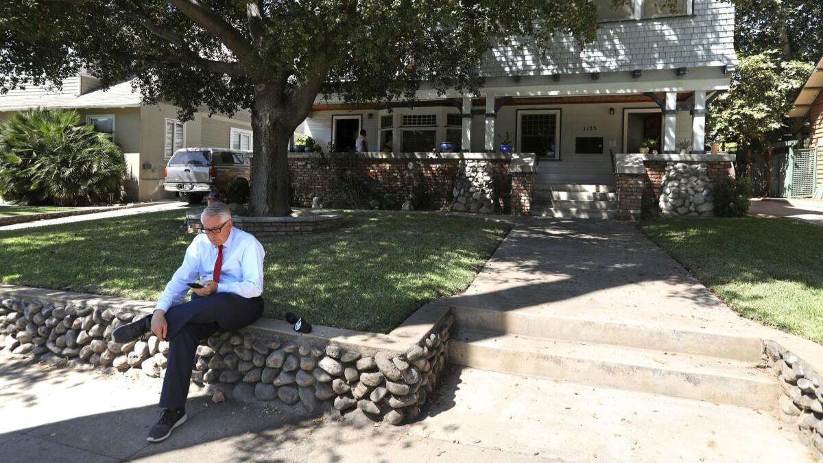 A reporter sits in front of the home where actress Vanessa Marquez was fatally shot by police.
