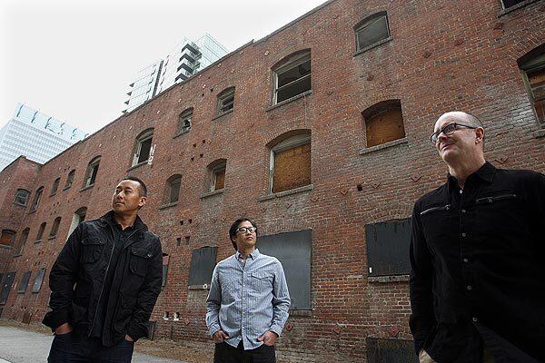 Rick Son, left, Brian Okazaki and Kevin Burke stand outside the downtown L.A. building they bought last year. They plan to transform the structure at 1130 S. Hope St. into a luxury boutique hotel. Full story