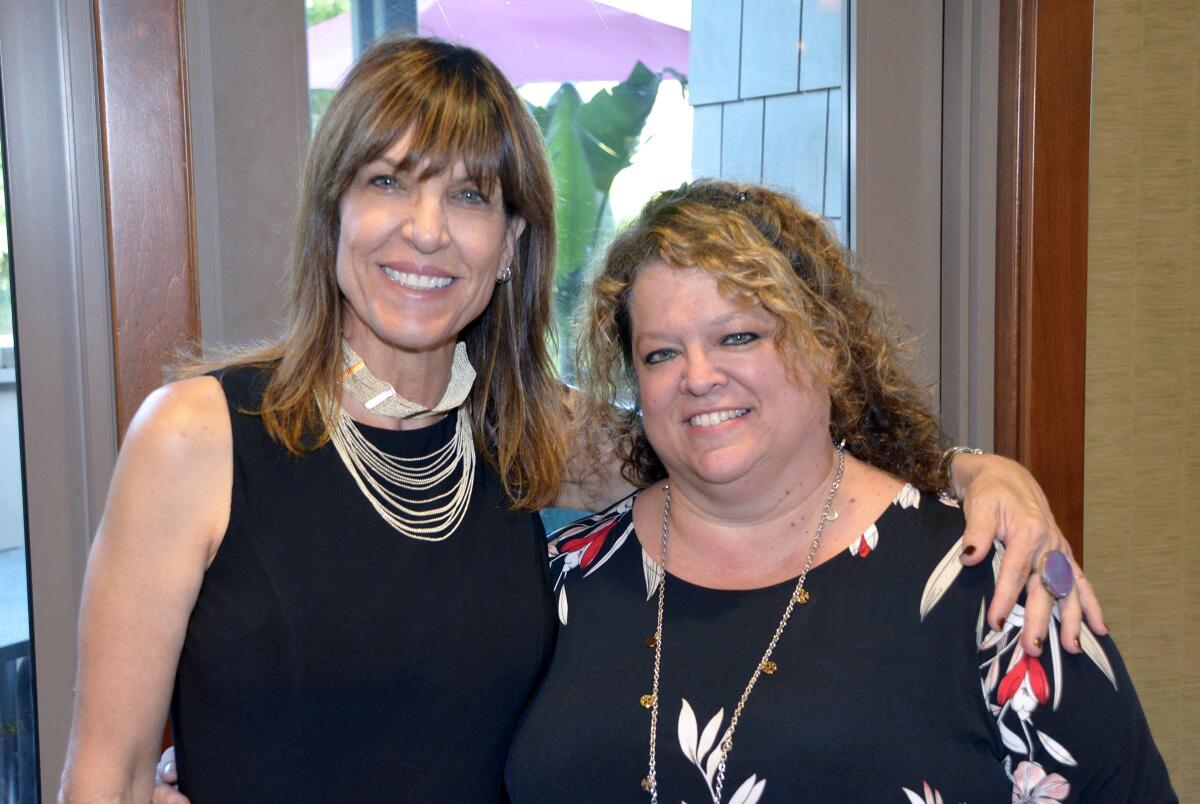 Among those who welcomed members and guests to the Burbank Chamber of Commerce’s August after hours mixer were staff member Mindy Kanaskie, left, and business ambassador Vickie Beckett.