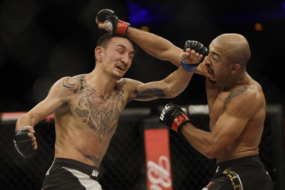 Jose Aldo, left, and Max Holloway trade punches during their featherweight championship fight at UFC 212.