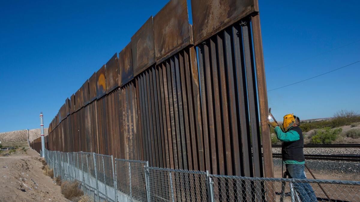 A worker welds a new fence between the Anapra neighborhood of Ciudad Juarez, Mexico, and Sunland Park, New Mexico, on March 30, 2017.