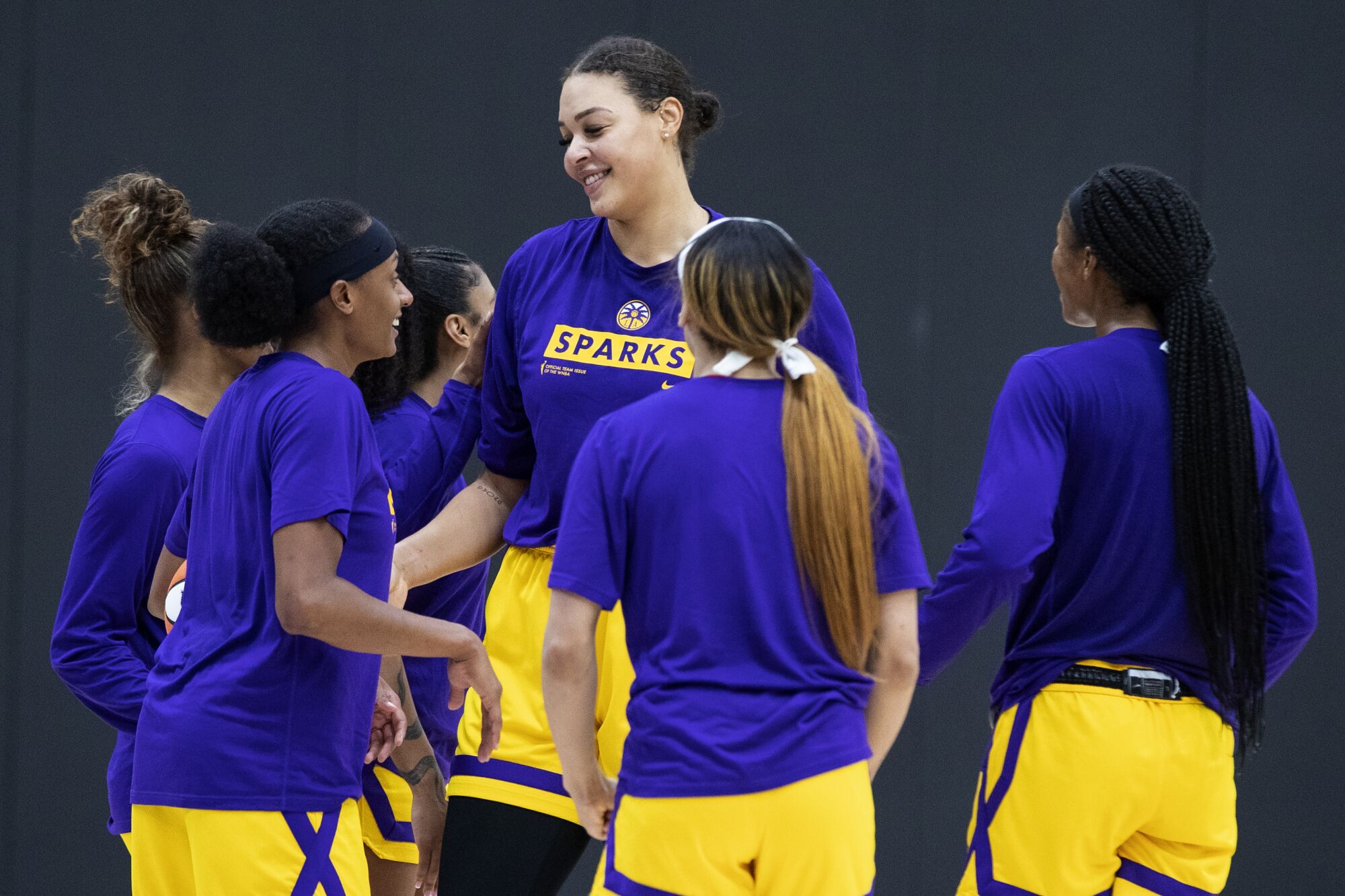 Six-foot-eight Liz Cambage is surrounded by Sparks teammates at practice.