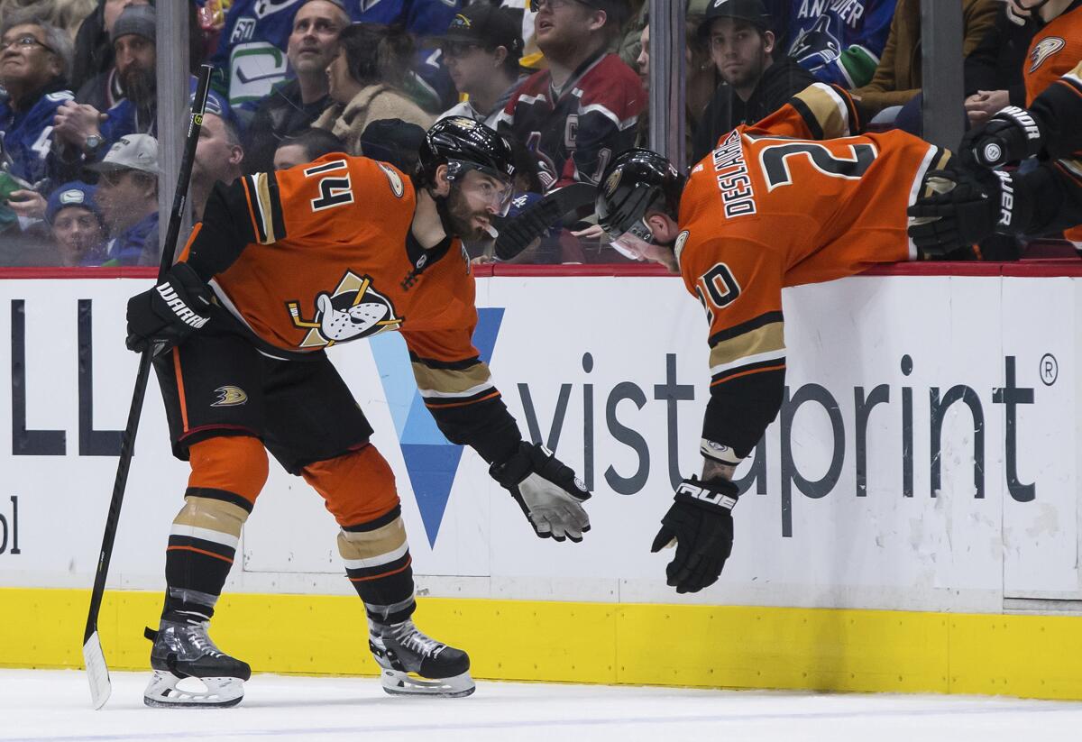 Ducks forward Adam Henrique, left, celebrates with teammate Nicolas Deslauriers after scoring during the second period of the Ducks' 5-1 win Sunday.
