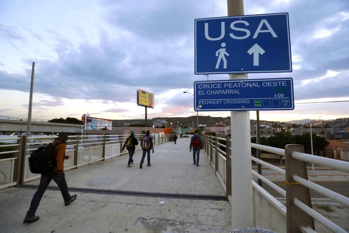 Algunos migrantes avanzan hacia el cruce fronterizo en Tijuana, México.