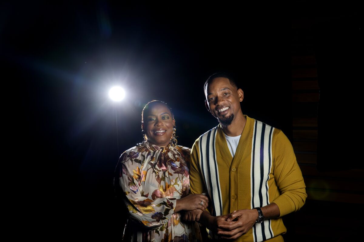 Will Smith and Aunjanue Ellis link arms for a portrait.