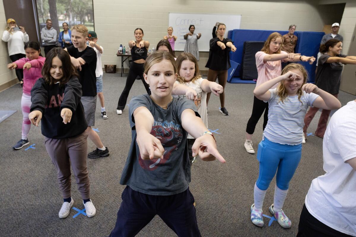 Newport Harbor's Olivia Winberry, center, helps lead a dance class for kids.
