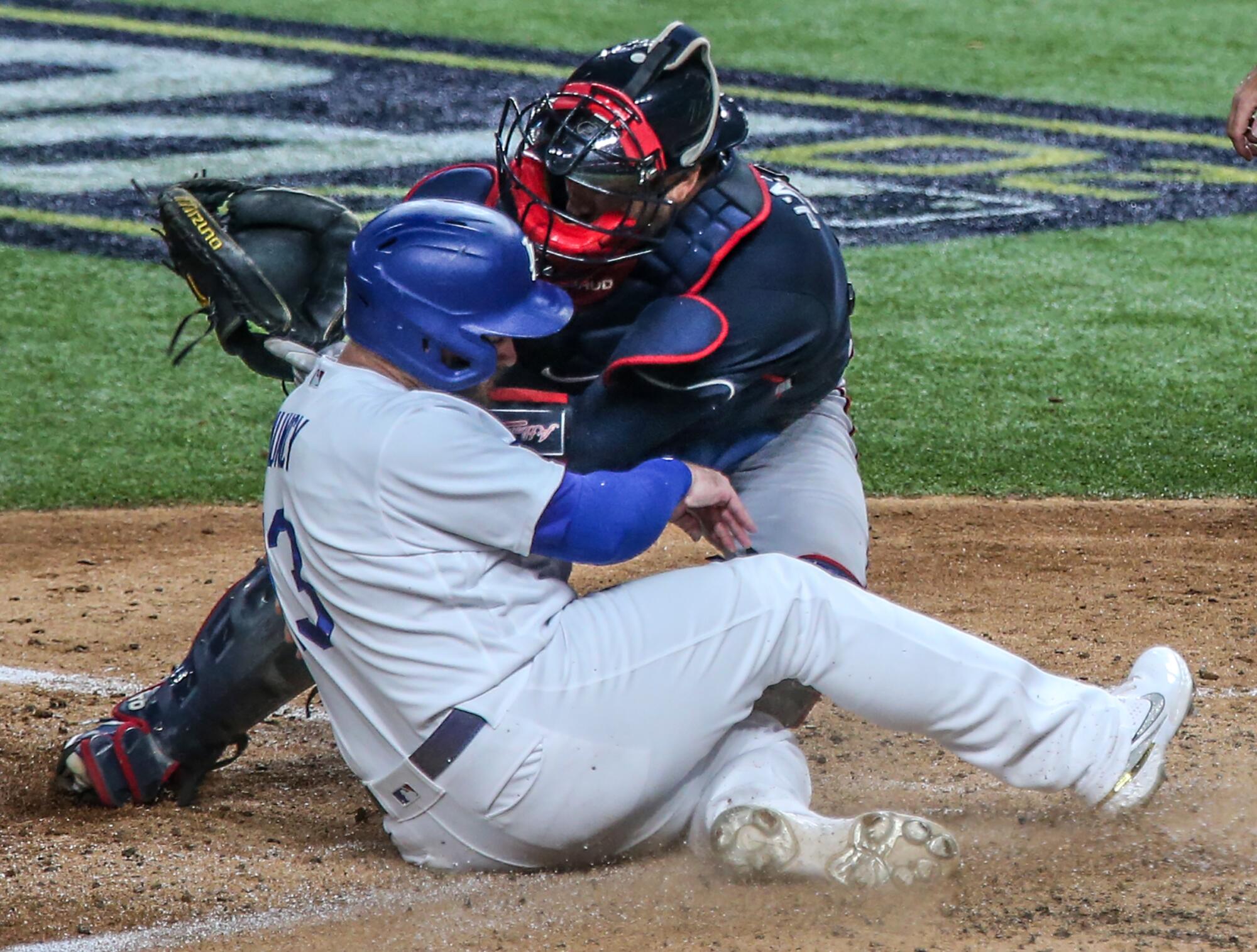 Max Muncy collides with Braves catcher Travis d'Arnaud at home plate.