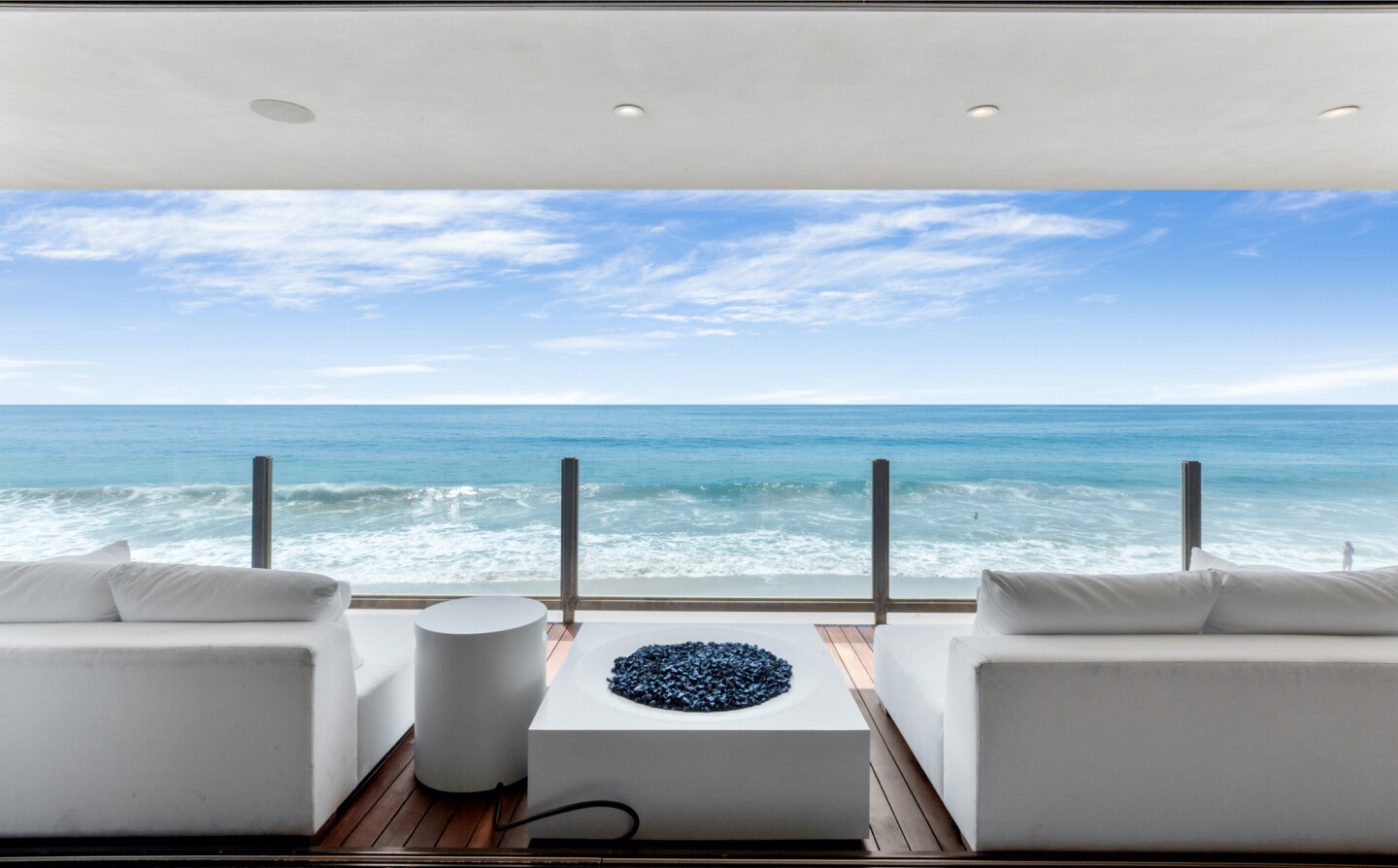 The architectural beach house expands to two levels of wood decks overlooking the ocean.