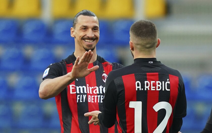Milan's Ante Rebic celebrates after scoring his side's first goal, with teammate Zlatan Ibrahimovic, who gave him the assist, during the Italian Serie A soccer match between Parma and Milan at the Ennio Tardini stadium in Parma, Italy, Saturday, April 10, 2021. (Spada/LaPresse via AP)
