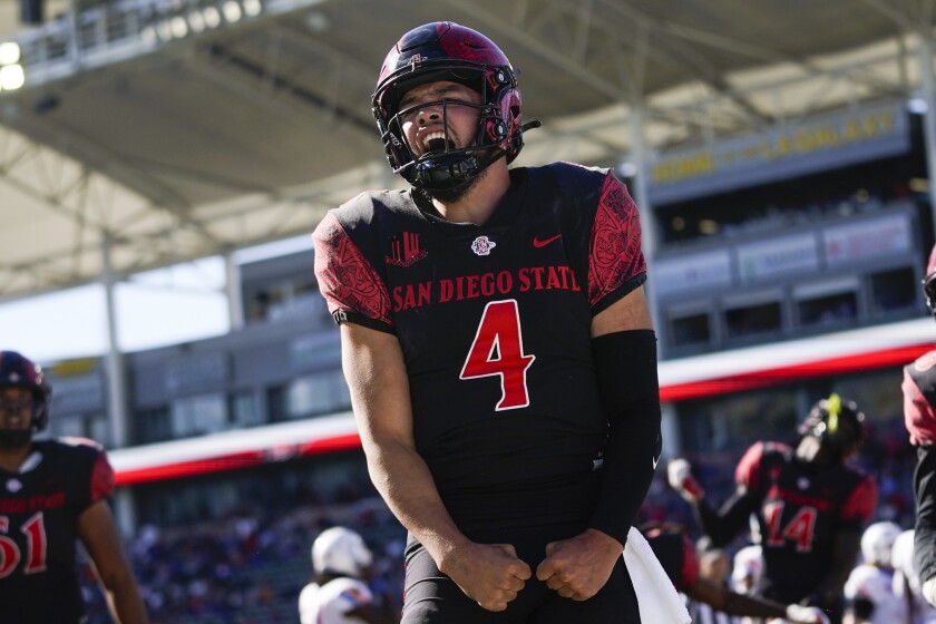 FILE - San Diego State quarterback Jordon Brookshire (4) celebrates after scoring a touchdown during the second half of an NCAA college football game against Boise State in Carson, Calif., on Nov. 26, 2021. The No. 19 San Diego State Aztecs have called the Los Angeles suburbs their home for two seasons while they're building a new stadium in Mission Valley. They'll host Utah State in the Mountain West Conference championship game Saturday in Carson. (AP Photo/Ashley Landis, File)