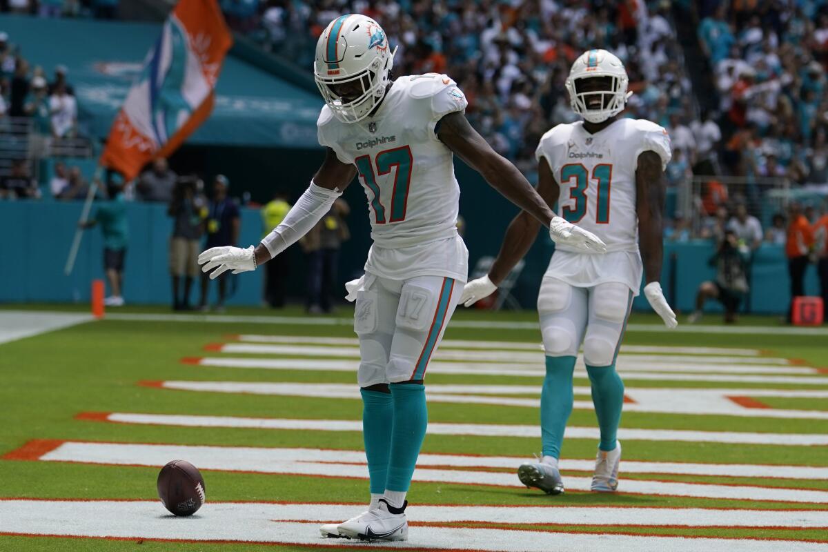 Miami Dolphins wide receiver Jaylen Waddle (17) and running back Raheem Mostert (31) do a dance after Waddle scored a touchdown during the first half of an NFL football game against the New England Patriots, Sunday, Sept. 11, 2022, in Miami Gardens, Fla. (AP Photo/Lynne Sladky)