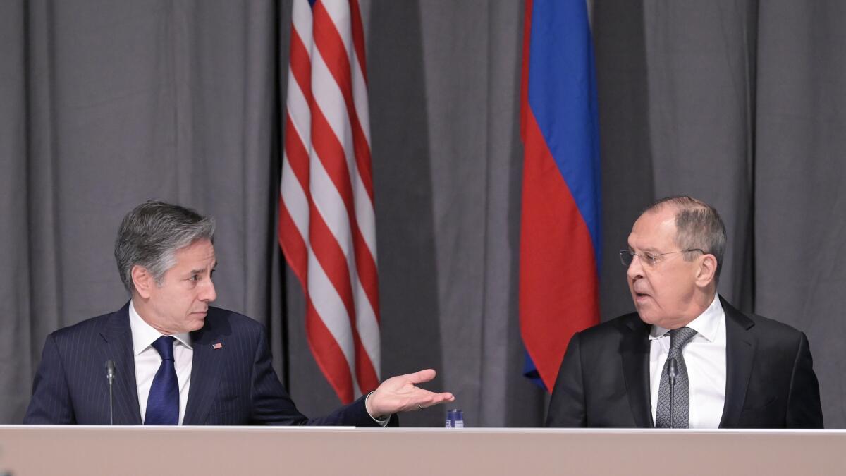 Secretary of State Antony Blinken gestures with an open hand  toward Russian Foreign Minister Sergey Lavrov in meeting.