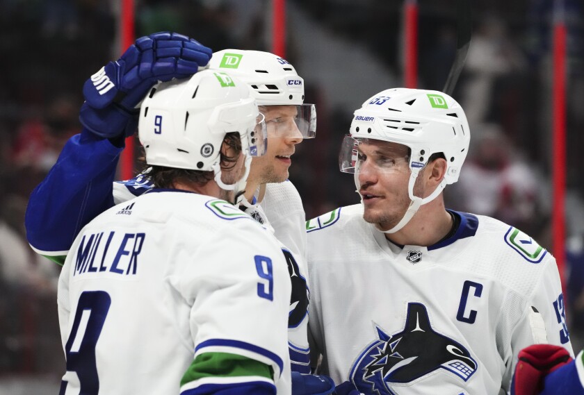 Vancouver Canucks center J.T. Miller (9), and teammates Alex Chiasson (39) and Bo Horvat (53) celebrate a goal against the Ottawa Senators during the third period of an NHL hockey game, Wednesday, Dec.1, 2021 in Ottawa, Ontario. (Sean Kilpatrick/The Canadian Press via AP)