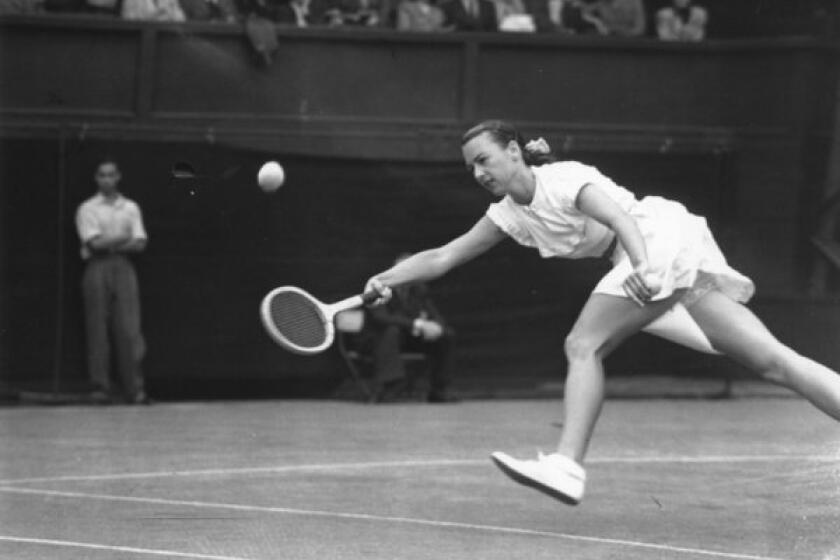American tennis player Gertrude 'Gussie' Moran stretches for the ball during her match against E M Wilford of Great Britain at Wimbledon on June 22, 1949.