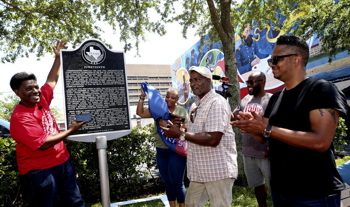 Sam Collins III, left, and others celebrate at the Juneteenth historical marker in Galveston, Texas, on June 17, 2021.